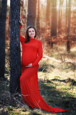 kobieta w lesie w długiej czerwonej sukience